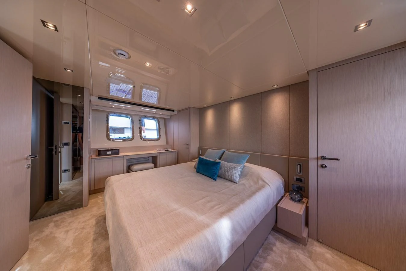 The stateroom features a plush bed with elegant bedding and ample natural light from the windows. aboard SX76 #144 Yacht for Sale