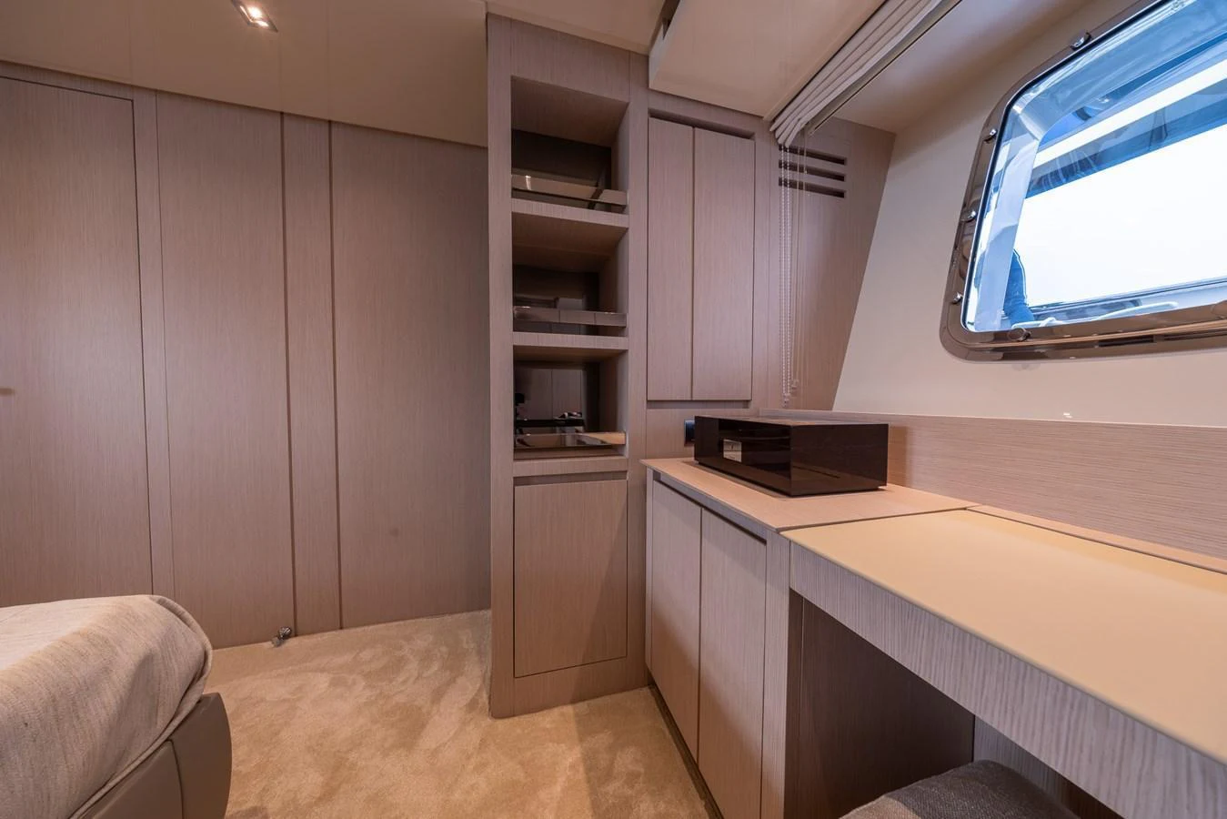 The yacht's cabin features a sleek and modern design with ample storage and a large window for natural light. aboard SX76 #144 Yacht for Sale