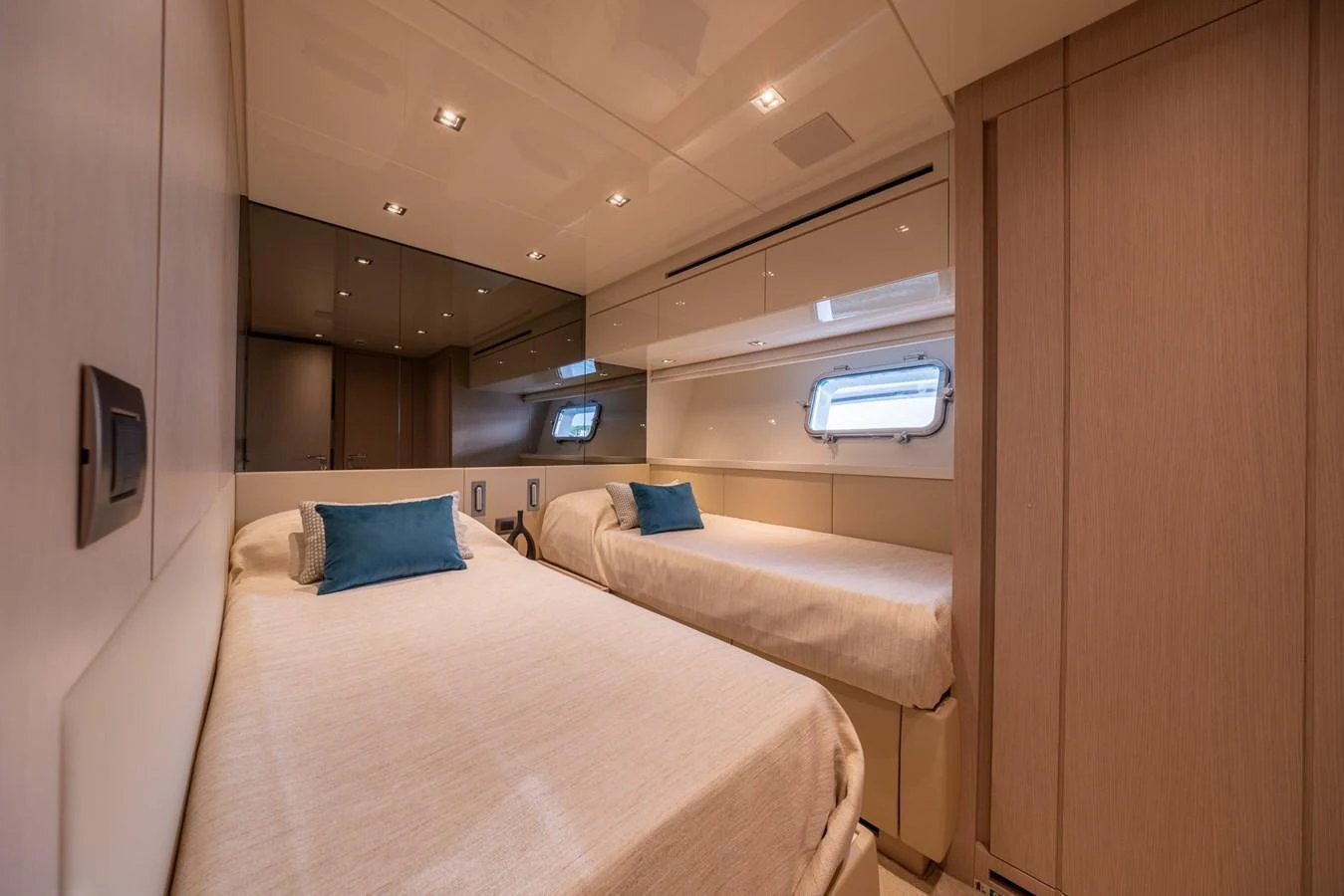 A cozy twin stateroom featuring two single beds with plush bedding and modern decor. aboard SX76 #144 Yacht for Sale