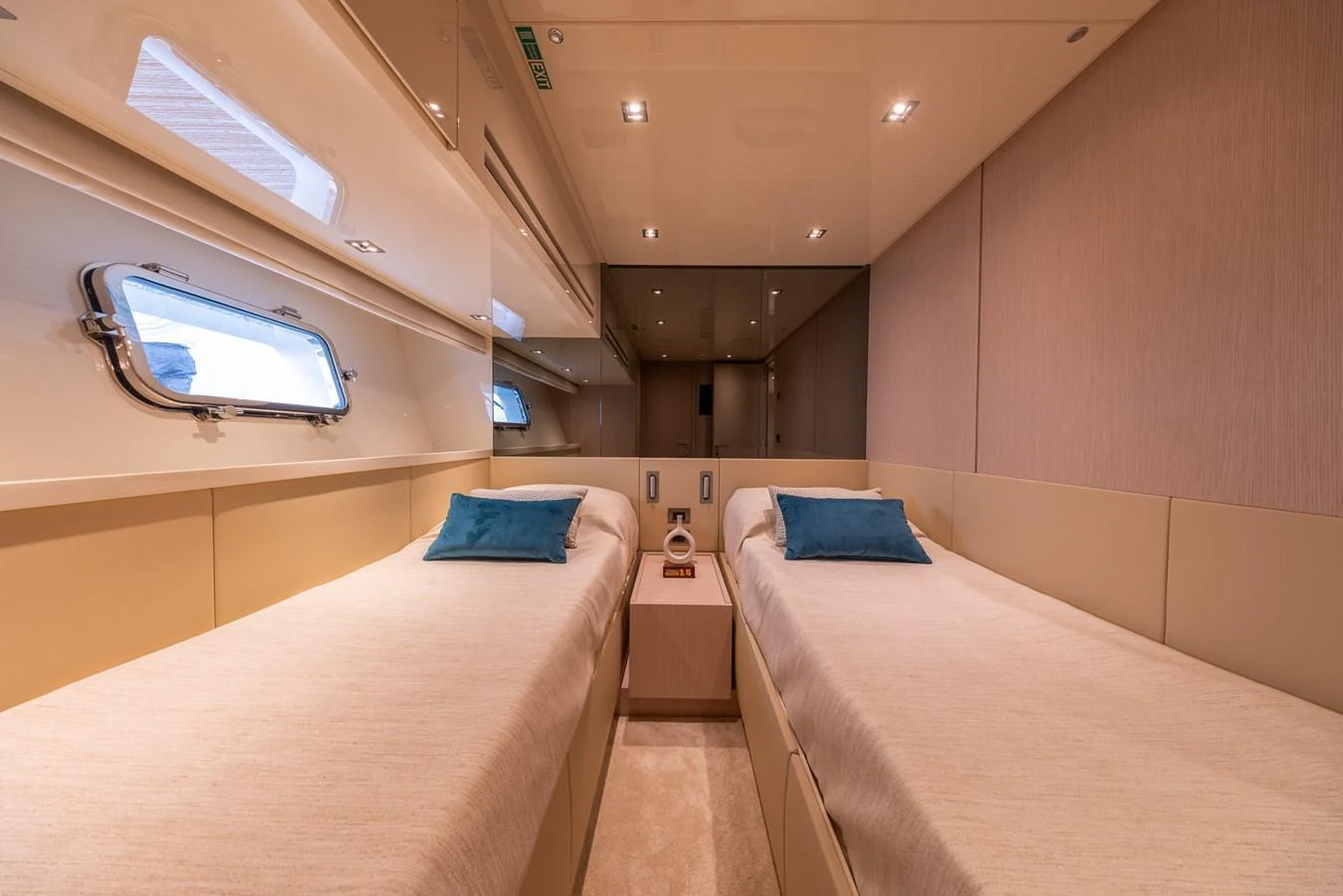 The twin stateroom offers a cozy and elegant space with two single beds and soft lighting. aboard SX76 #144 Yacht for Sale