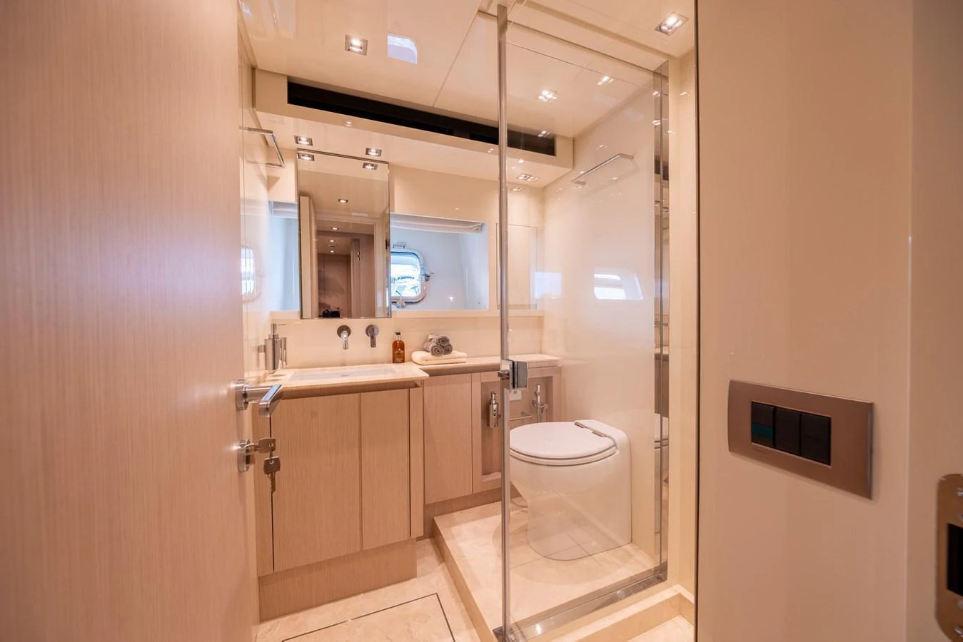 The yacht's bathroom features elegant fixtures and a spacious glass-enclosed shower. aboard SX76 #144 Yacht for Sale