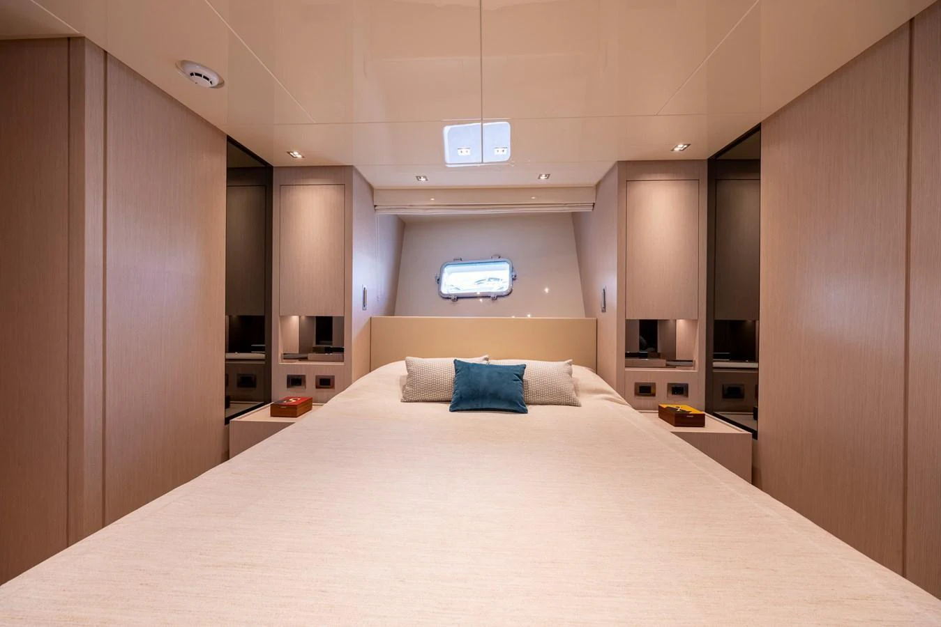 The stateroom features a spacious bed with elegant wood finishes and a window providing natural light. aboard SX76 #144 Yacht for Sale