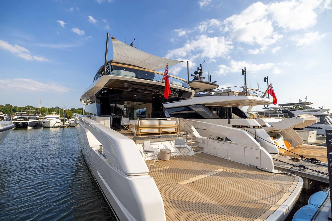 The yacht's aft deck offers a spacious and inviting area for relaxation and socializing, with elegant wood decking and a shaded upper deck. aboard SX76 #144 Yacht for Sale