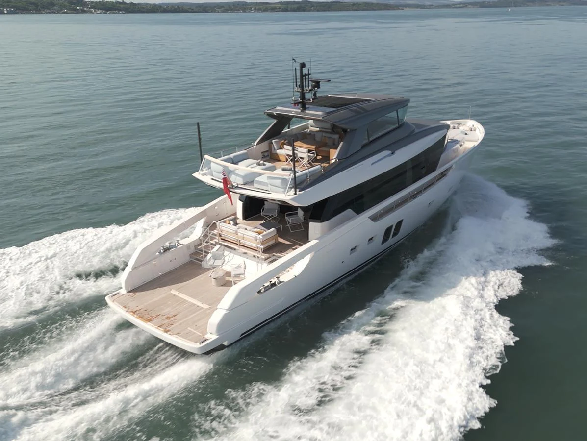 A sleek and modern yacht cruising through calm waters, showcasing its spacious deck and elegant design. aboard SX76 #144 Yacht for Sale