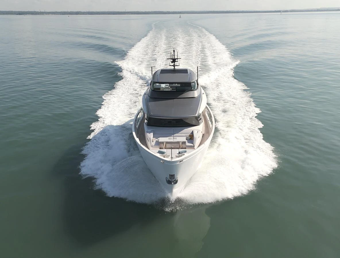 A sleek yacht cruises forward, leaving a trail of white water behind. aboard SX76 #144 Yacht for Sale