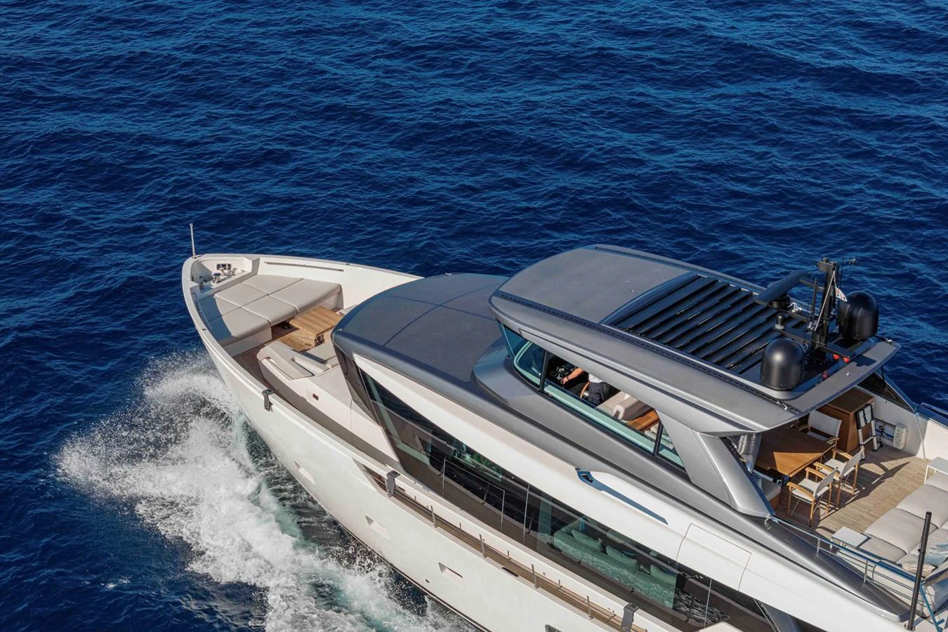 A sleek yacht cruises through the deep blue waters, showcasing its modern design and spacious deck areas. aboard FIREFLY Yacht for Sale