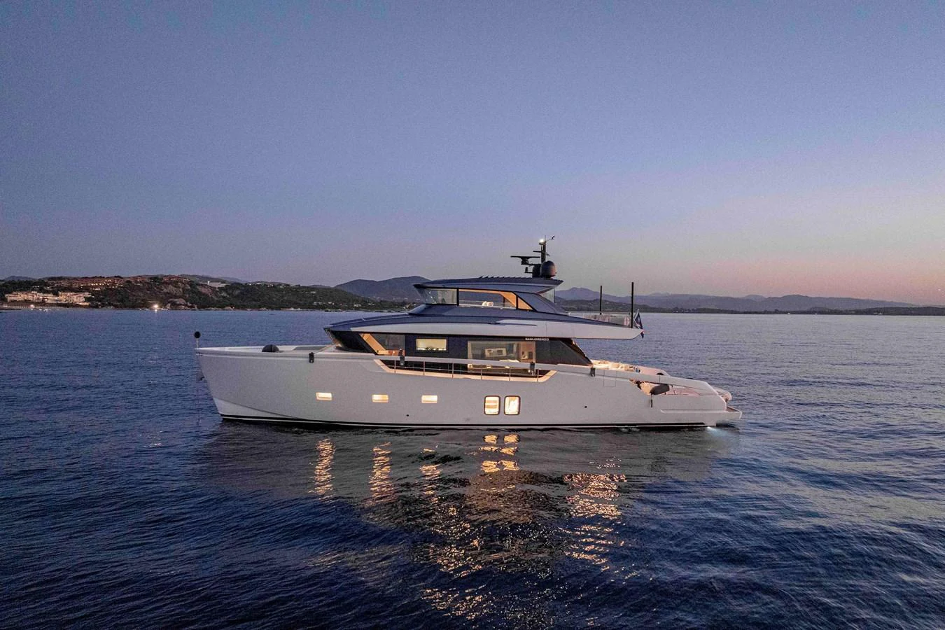 A sleek and modern yacht glides gracefully on calm waters during twilight. aboard FIREFLY Yacht for Sale