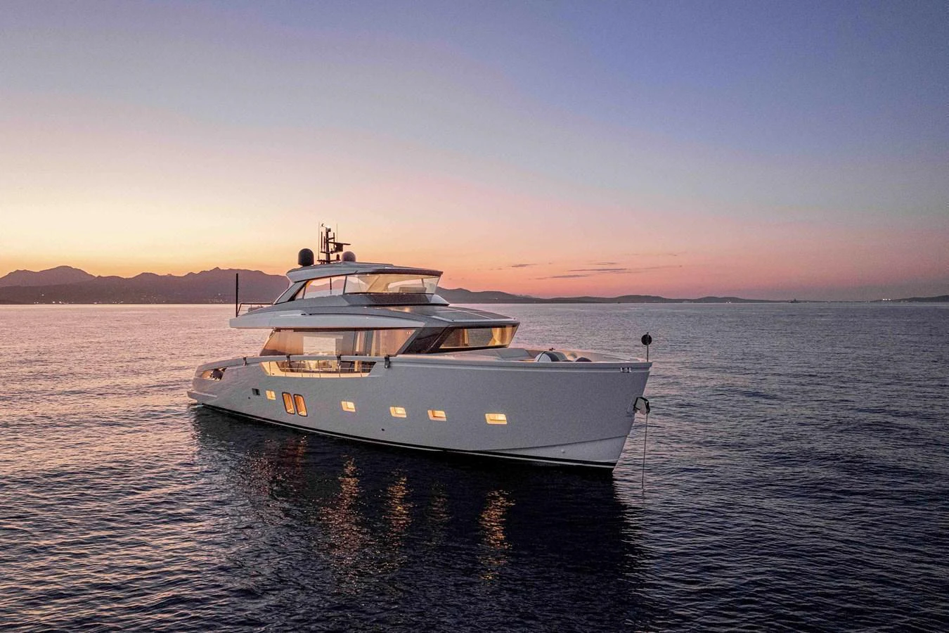 A sleek yacht glides gracefully on calm waters during a stunning sunset. aboard FIREFLY Yacht for Sale