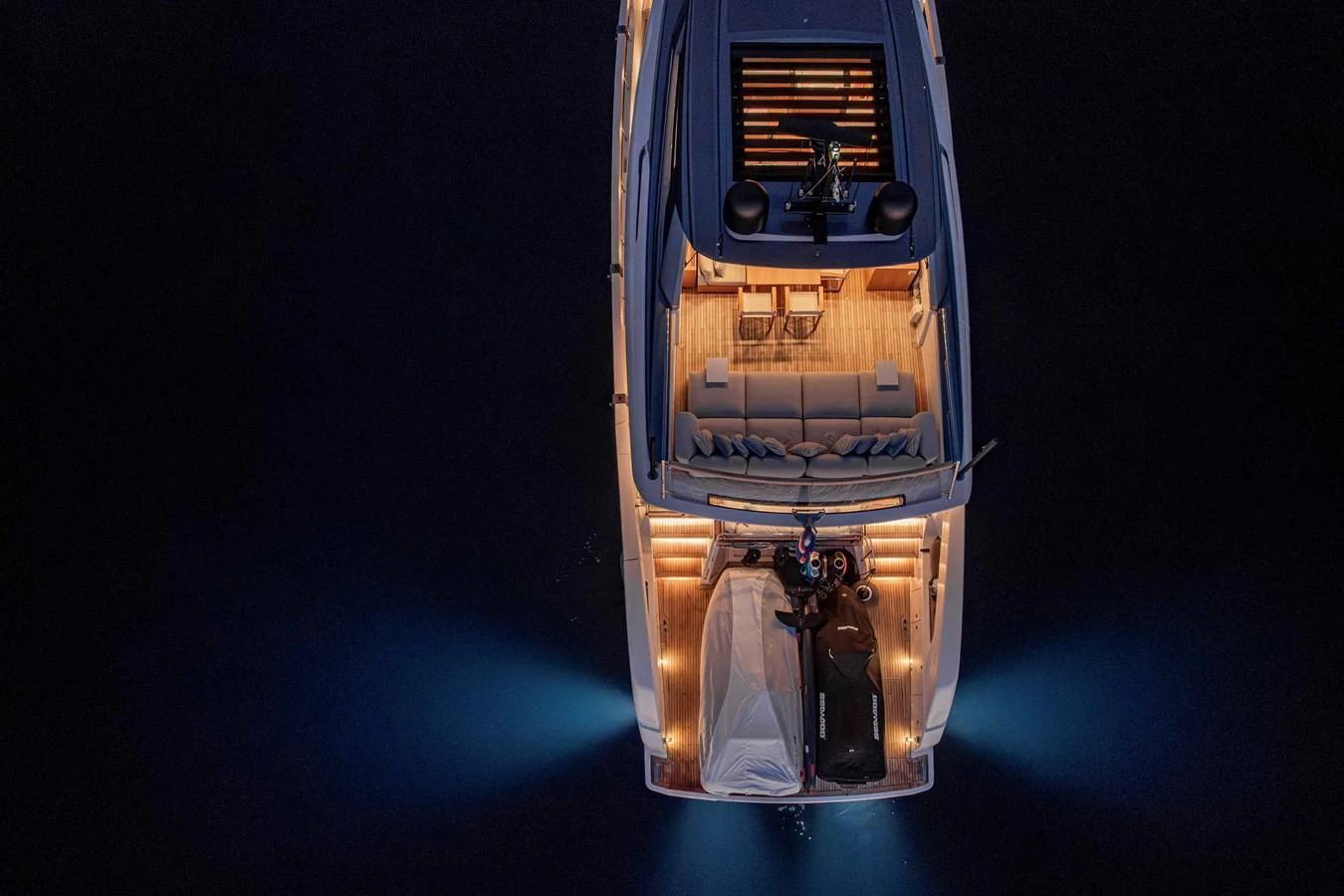 An aerial view of a yacht's illuminated aft deck at night, showcasing its elegant design and inviting ambiance. aboard FIREFLY Yacht for Sale