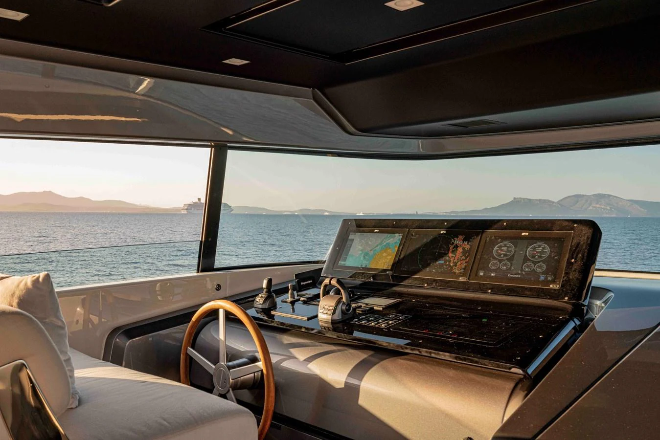The helm station offers a panoramic view of the serene waters and distant mountains. aboard FIREFLY Yacht for Sale