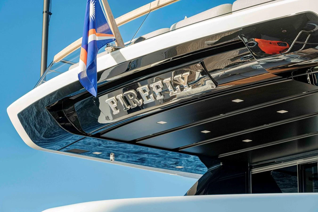 A close-up view of the yacht's stern showcasing its name and sleek design. aboard FIREFLY Yacht for Sale