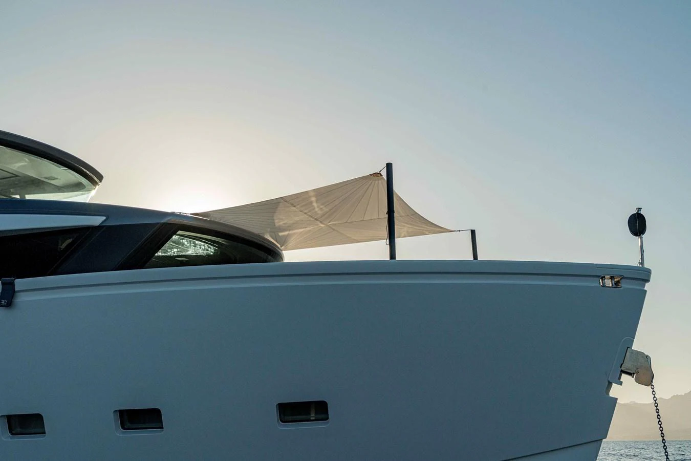 A sleek yacht exterior with a sunshade on the deck, captured against a serene sky. aboard FIREFLY Yacht for Sale