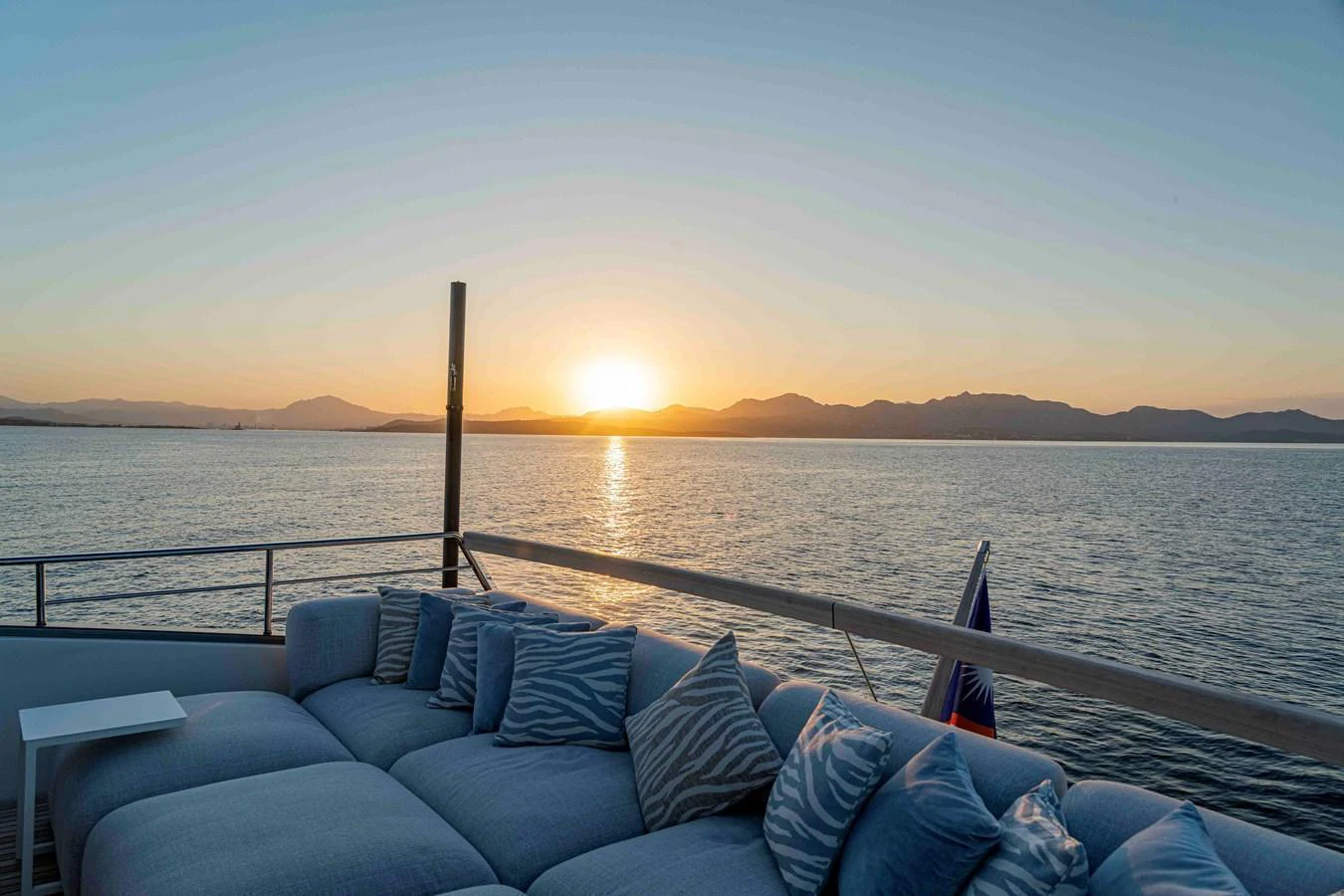The aft deck offers a serene lounging area with plush seating, perfect for enjoying sunsets over the water. aboard FIREFLY Yacht for Sale