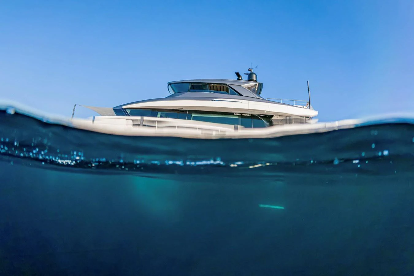 A sleek yacht cruising on calm waters with a clear blue sky above. aboard FIREFLY Yacht for Sale