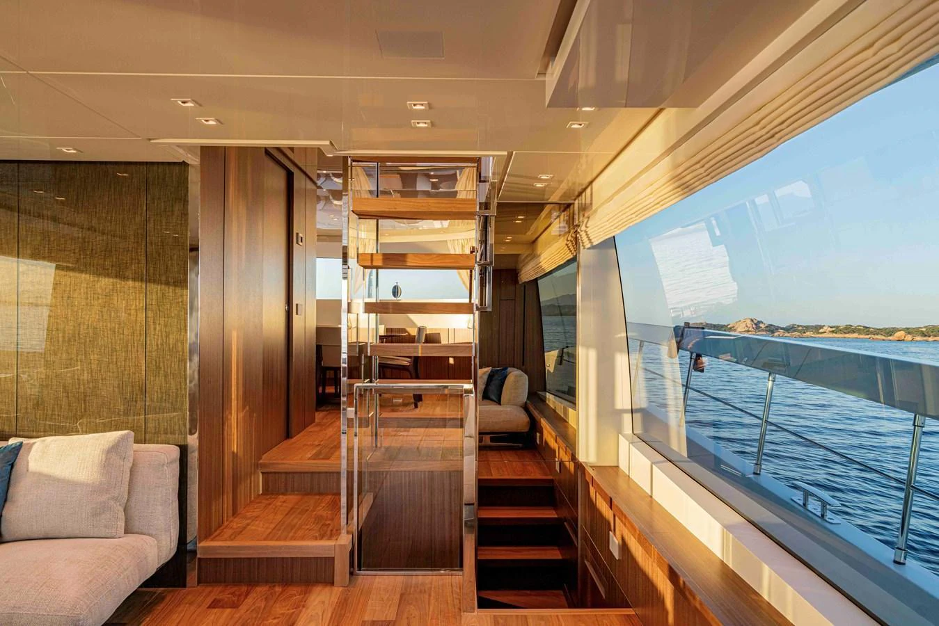 The yacht's salon features elegant wooden flooring, plush seating, and expansive windows offering stunning ocean views. aboard FIREFLY Yacht for Sale
