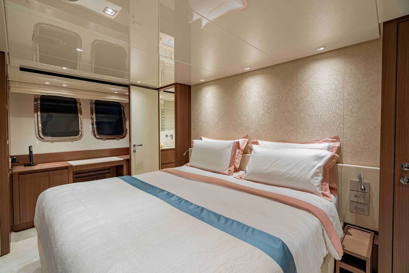 The stateroom features a plush double bed with elegant bedding and ample natural light from the windows. aboard FIREFLY Yacht for Sale