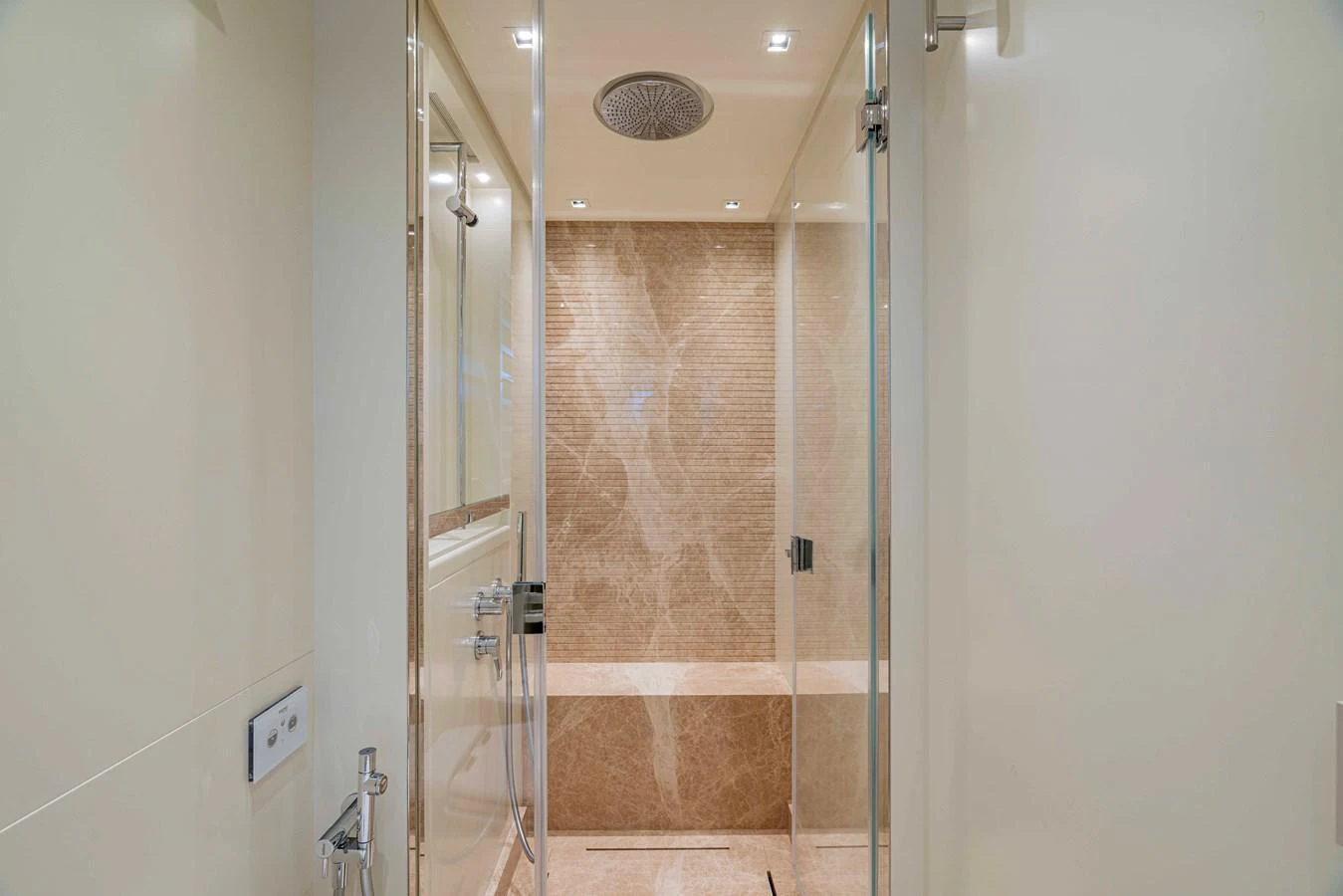 The yacht's bathroom features a luxurious shower area with elegant marble tiles and modern fixtures. aboard FIREFLY Yacht for Sale