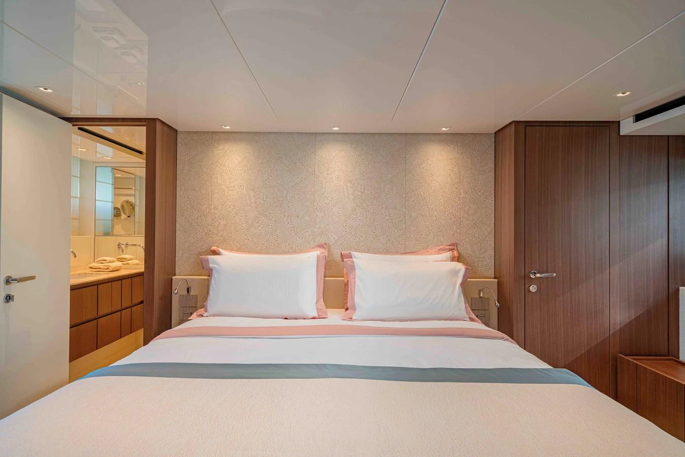 A luxurious stateroom featuring a comfortable double bed with elegant bedding and warm lighting. aboard FIREFLY Yacht for Sale