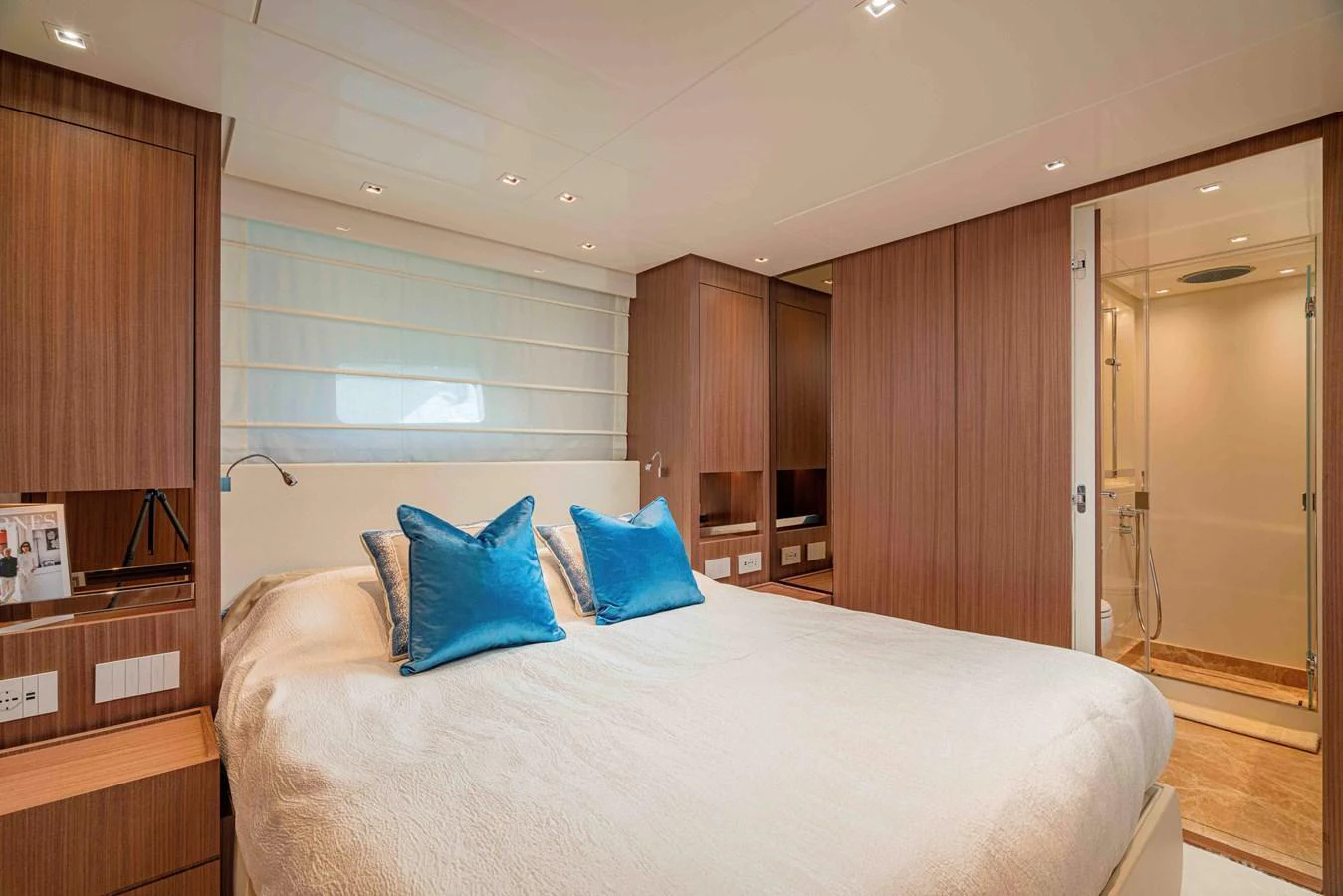 The stateroom features a cozy bed with plush pillows and a modern ensuite bathroom. aboard FIREFLY Yacht for Sale