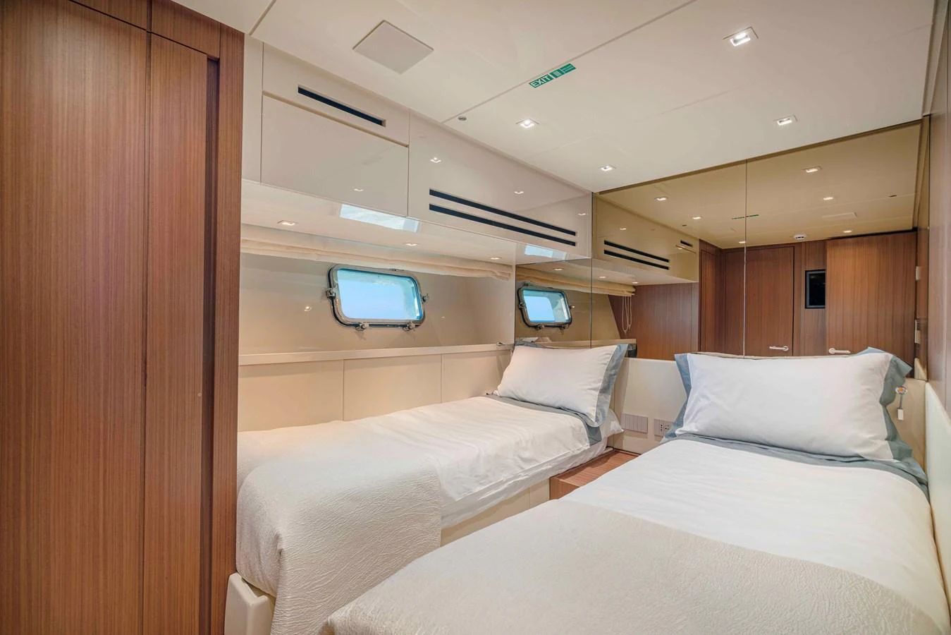 The guest stateroom features twin beds with elegant wooden paneling and ample natural light. aboard FIREFLY Yacht for Sale