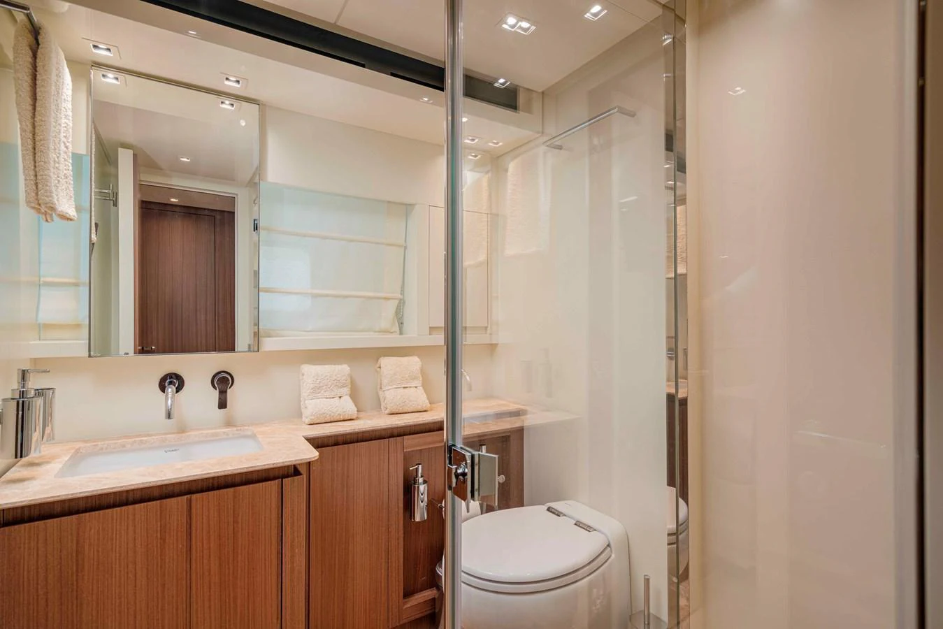 The yacht's bathroom features modern fixtures and a sleek design with ample lighting. aboard FIREFLY Yacht for Sale