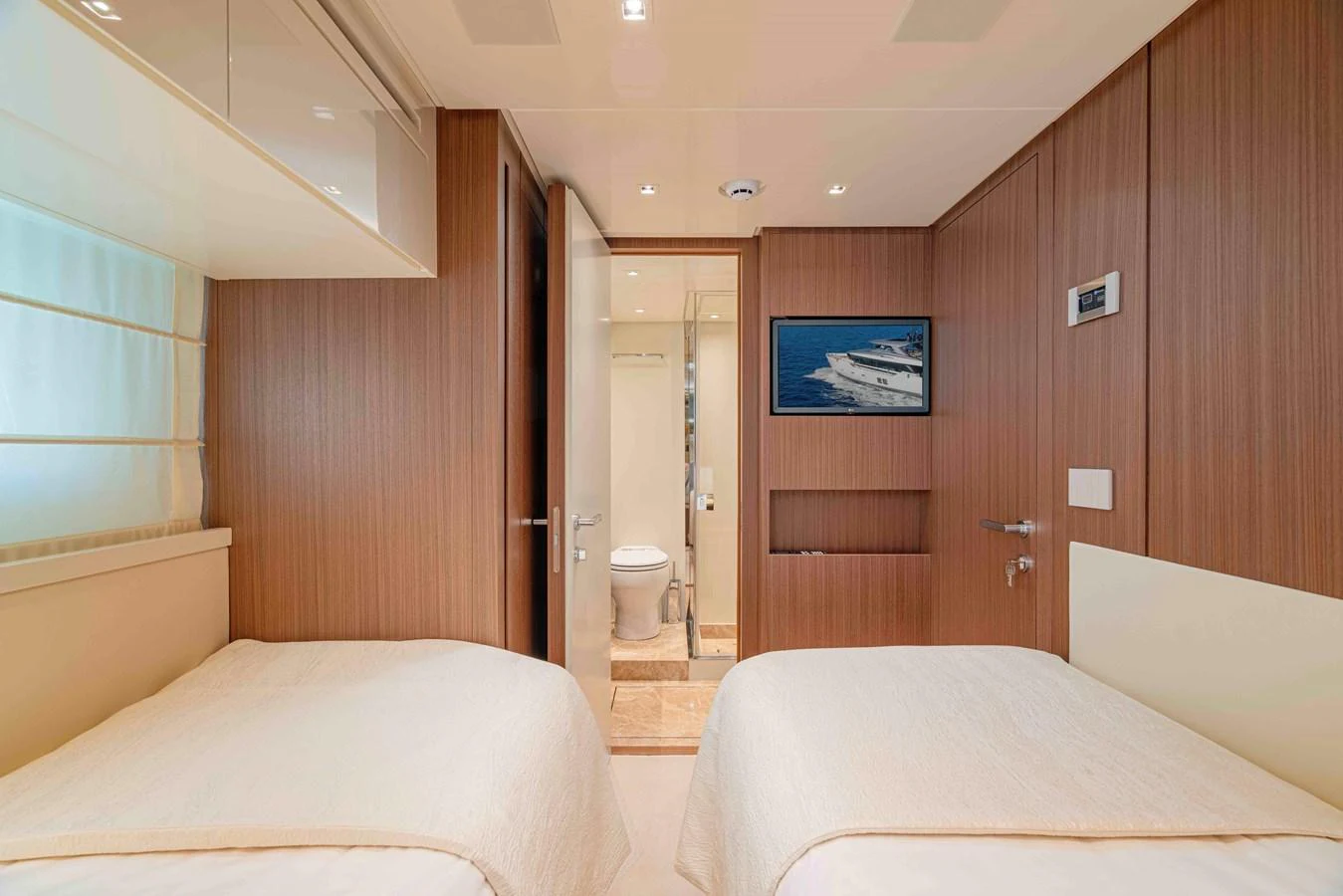 The guest stateroom features twin beds and a private ensuite bathroom, offering a cozy and comfortable retreat. aboard FIREFLY Yacht for Sale