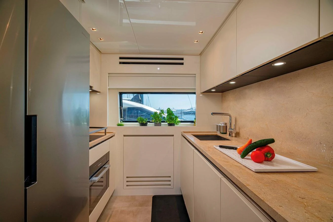 The yacht's galley features modern appliances and a sleek design with a view of the water through the window. aboard FIREFLY Yacht for Sale