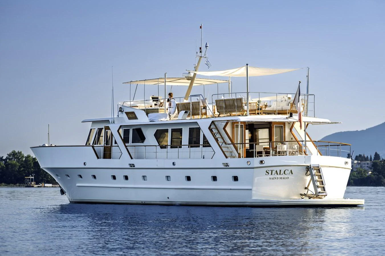 A classic yacht with a spacious deck and elegant design, cruising on calm waters. aboard STALCA Yacht for Sale