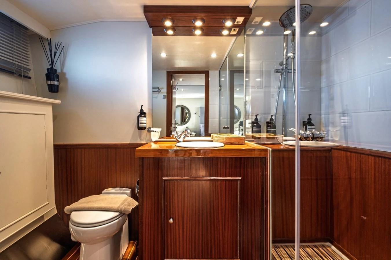 The yacht's bathroom features elegant wood paneling and modern fixtures for a luxurious experience. aboard STALCA Yacht for Sale