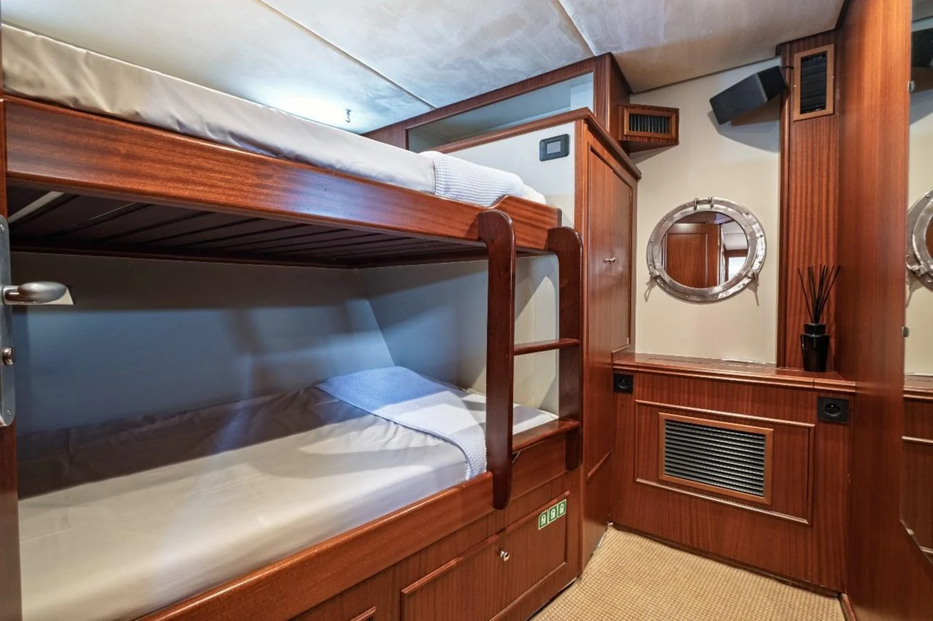 The cozy bunk room features wooden finishes and round porthole windows, offering a comfortable sleeping space. aboard STALCA Yacht for Sale