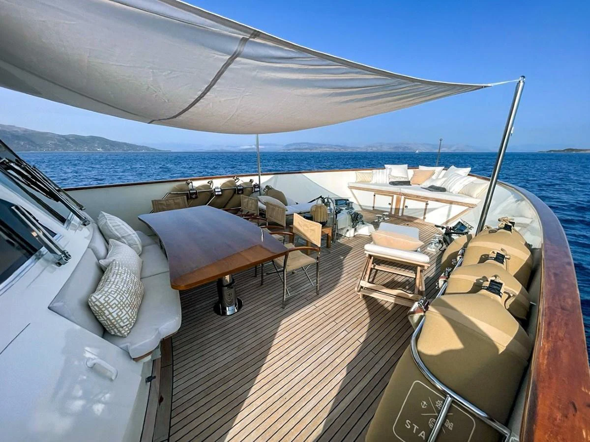 The foredeck features a spacious seating area with a large table and sunshade, perfect for outdoor relaxation and dining. aboard STALCA Yacht for Sale