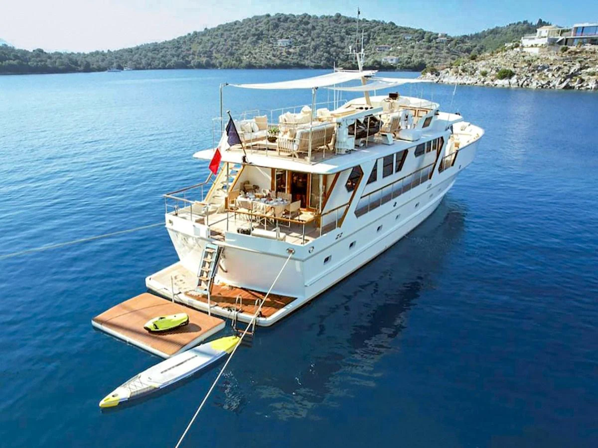 A luxurious yacht anchored in a serene bay, showcasing its spacious aft deck and water toys. aboard STALCA Yacht for Sale