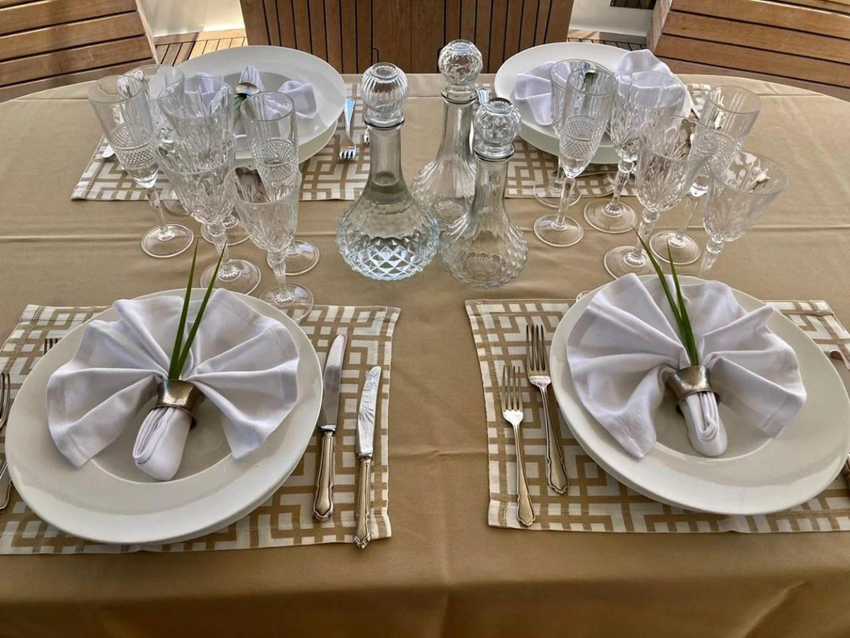 An elegantly set dining table with fine glassware and napkins folded in a sophisticated manner. aboard STALCA Yacht for Sale