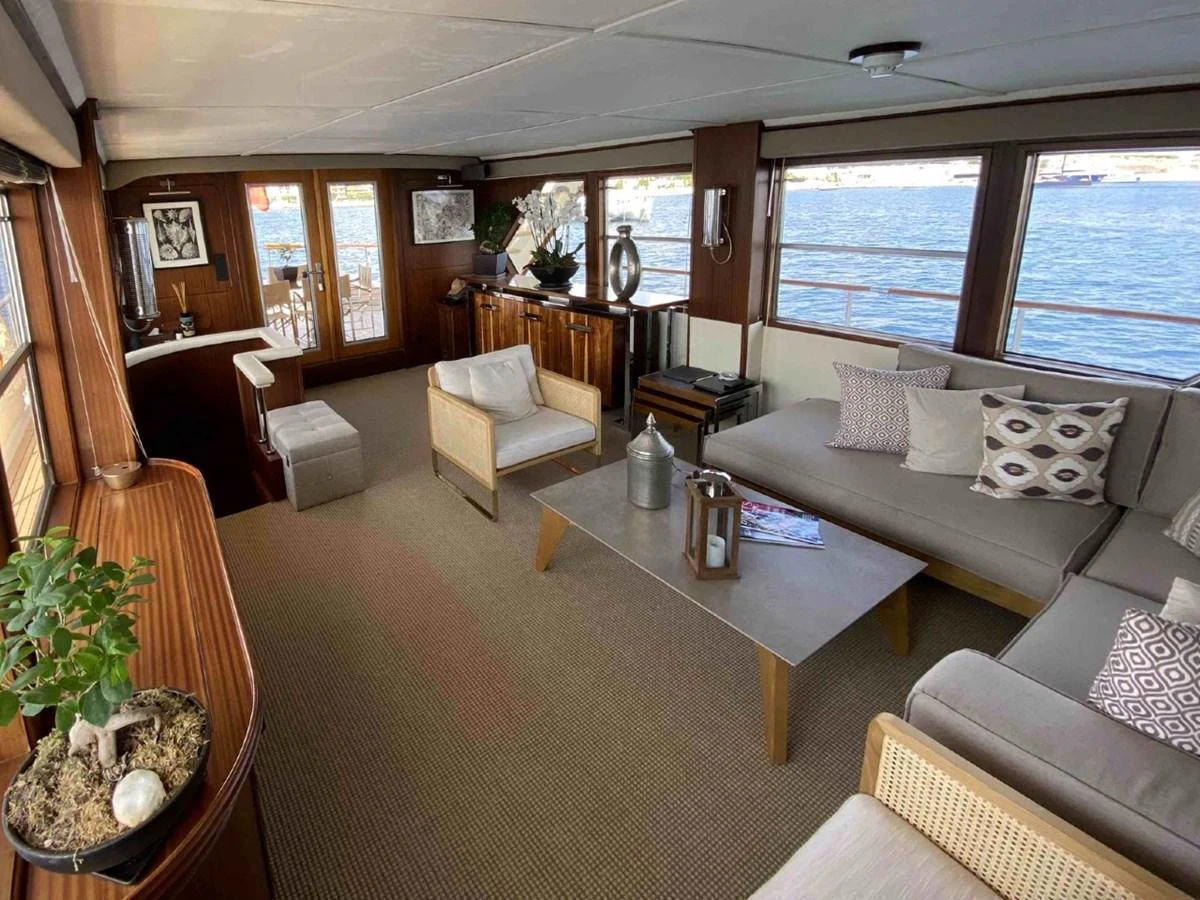 The salon offers a spacious and elegantly furnished area with large windows providing stunning views of the water. aboard STALCA Yacht for Sale
