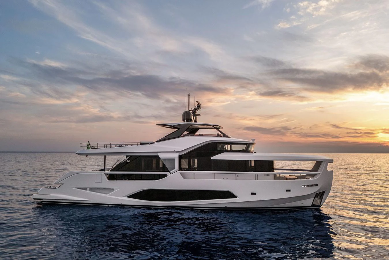 A sleek and modern yacht glides gracefully on calm waters at sunset. aboard INFYNITO 80 Yacht for Sale