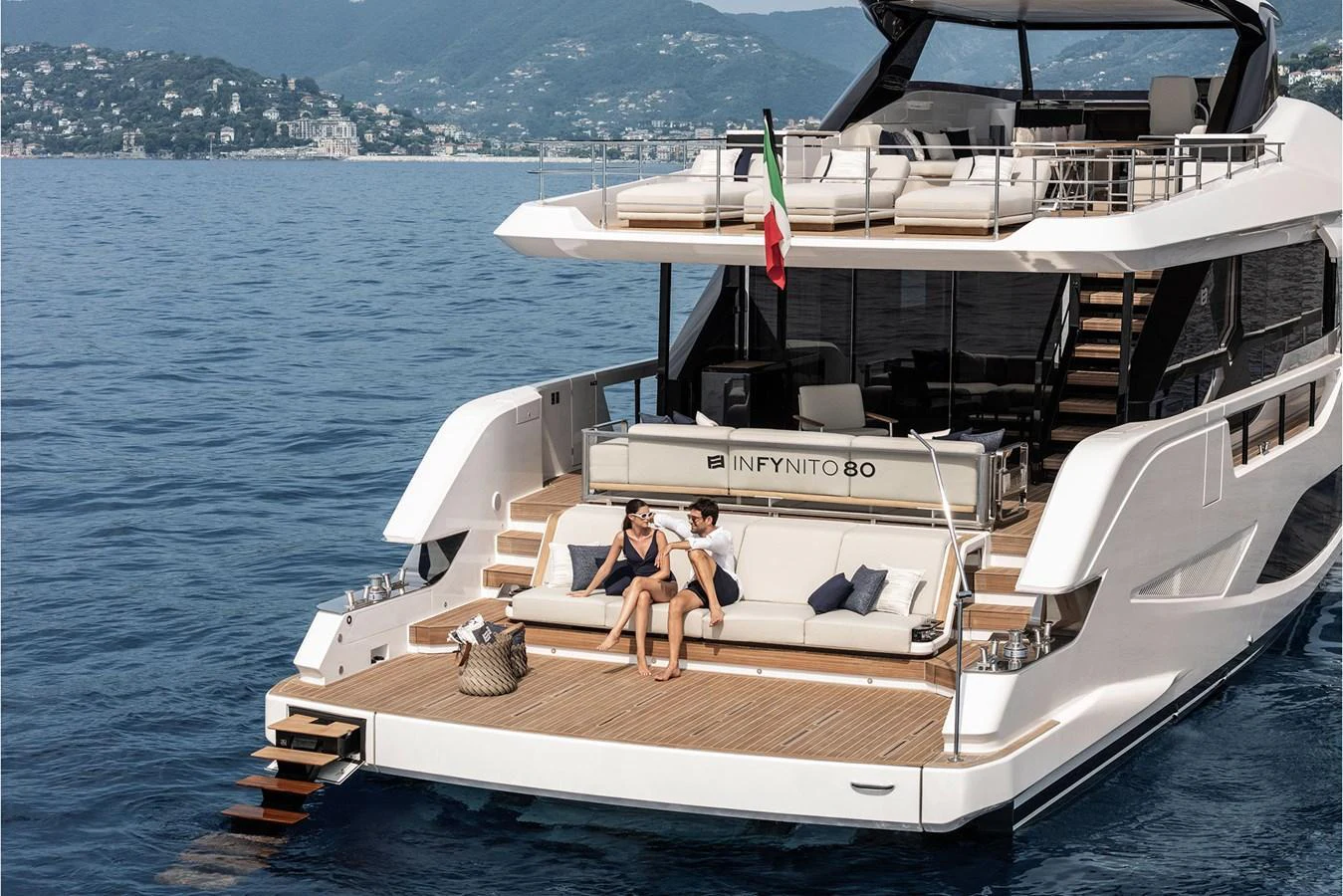 The yacht's aft deck features a spacious lounging area with a stunning view of the surrounding waters. aboard INFYNITO 80 Yacht for Sale