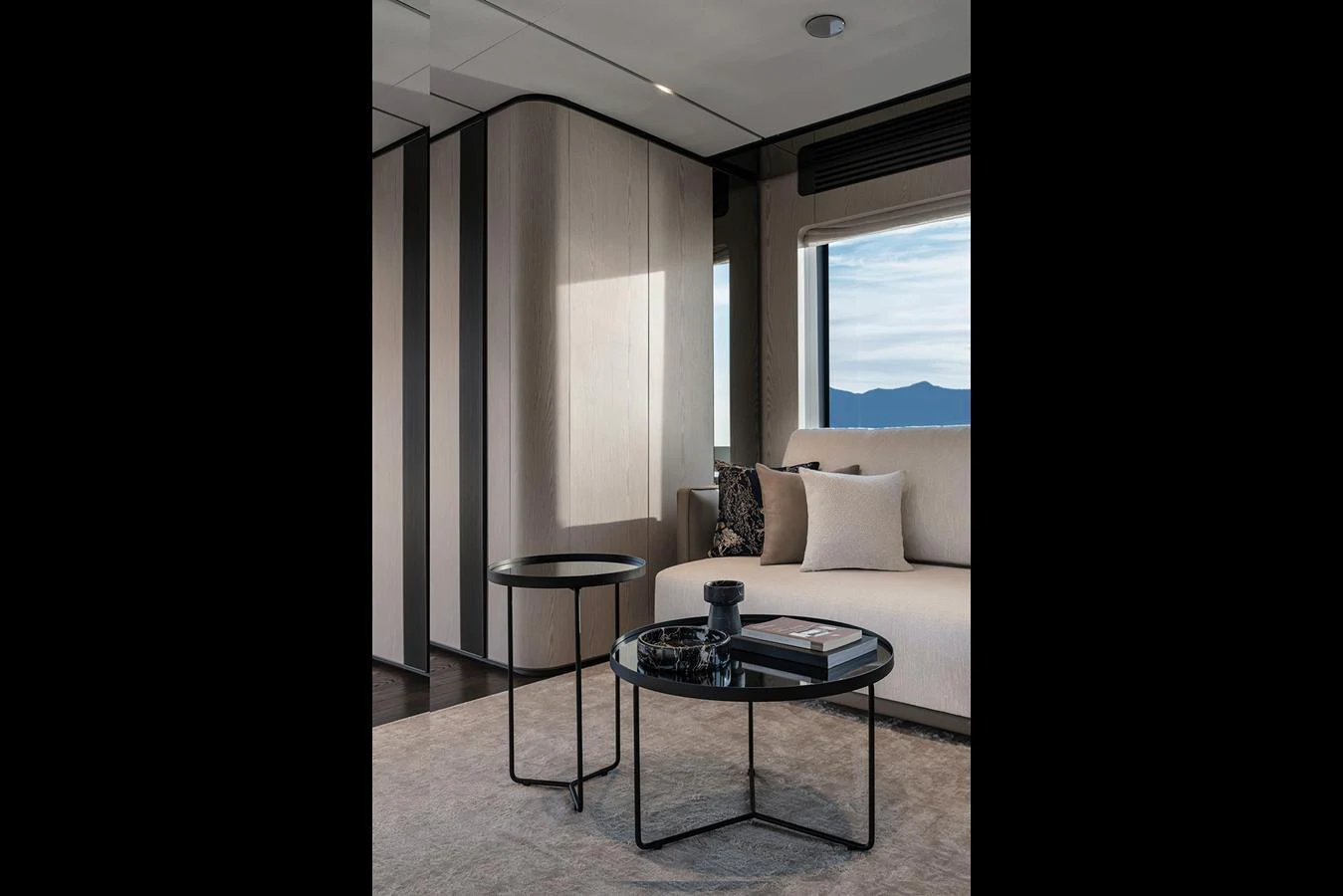 A stylish and modern yacht interior featuring a comfortable seating area with a scenic view. aboard INFYNITO 80 Yacht for Sale