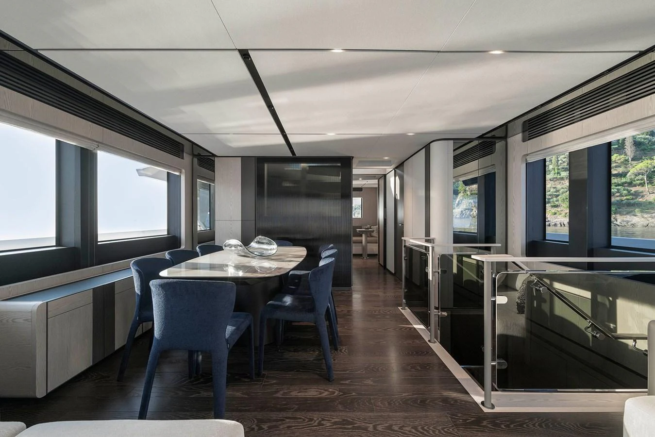 The yacht's dining area features modern furnishings with ample natural light from large windows. aboard INFYNITO 80 Yacht for Sale