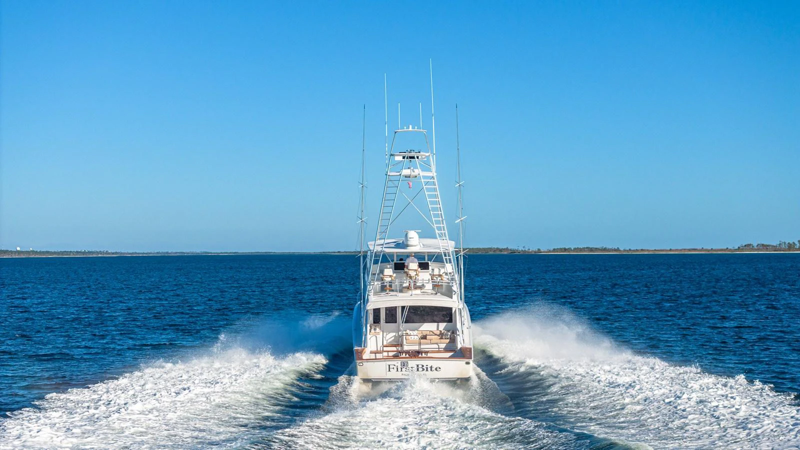 A yacht cruises through open waters, leaving a trail of white wake behind. aboard FIRST BITE Yacht for Sale