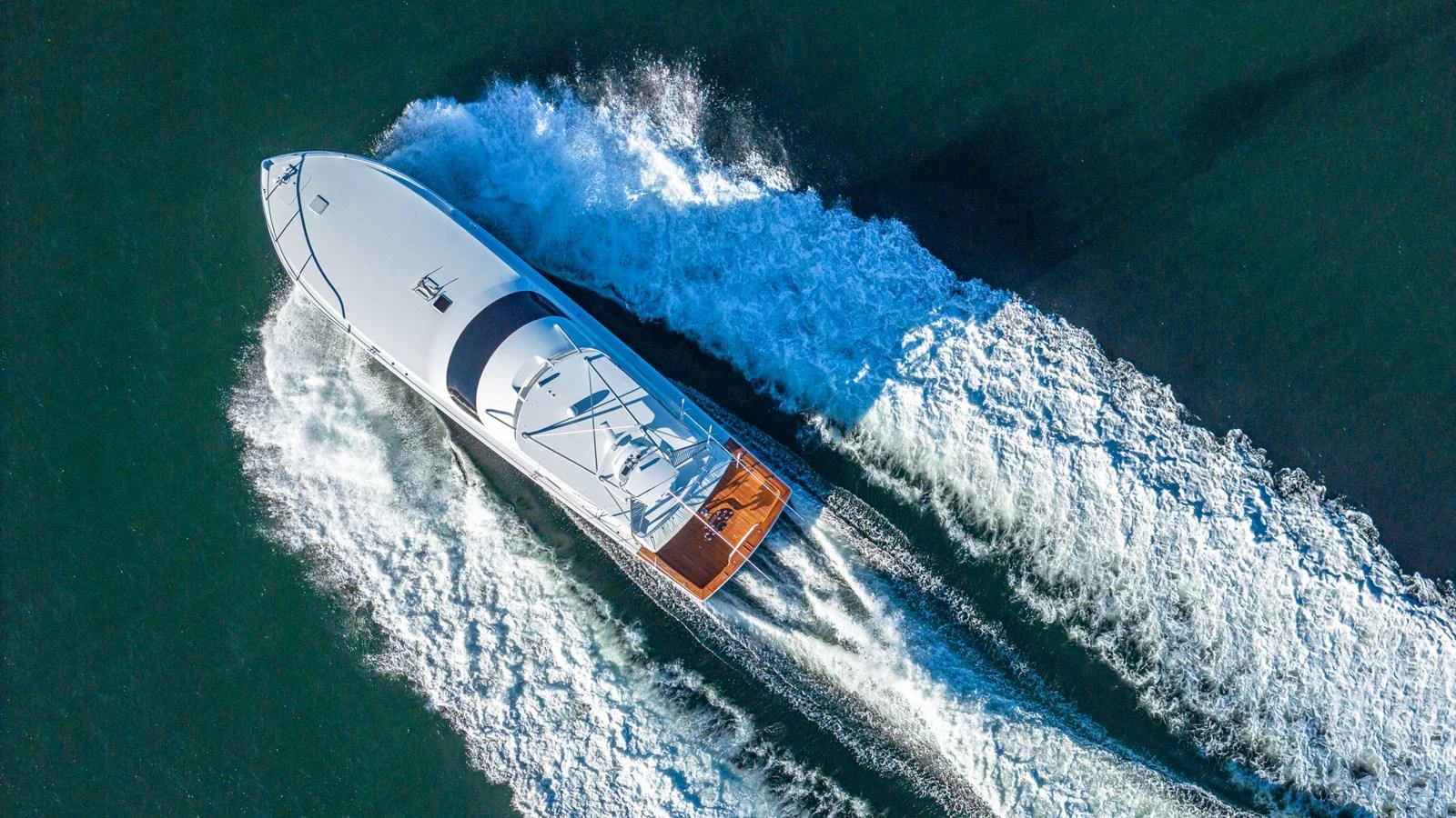 A sleek yacht cuts through the water, leaving a trail of white foam in its wake. aboard FIRST BITE Yacht for Sale