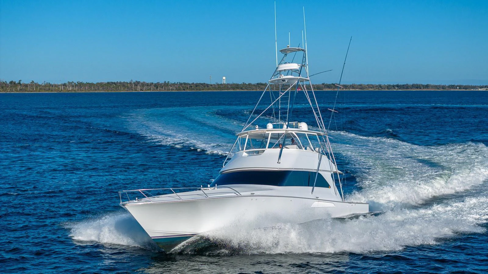A sleek yacht cruises swiftly through calm waters on a clear day. aboard FIRST BITE Yacht for Sale