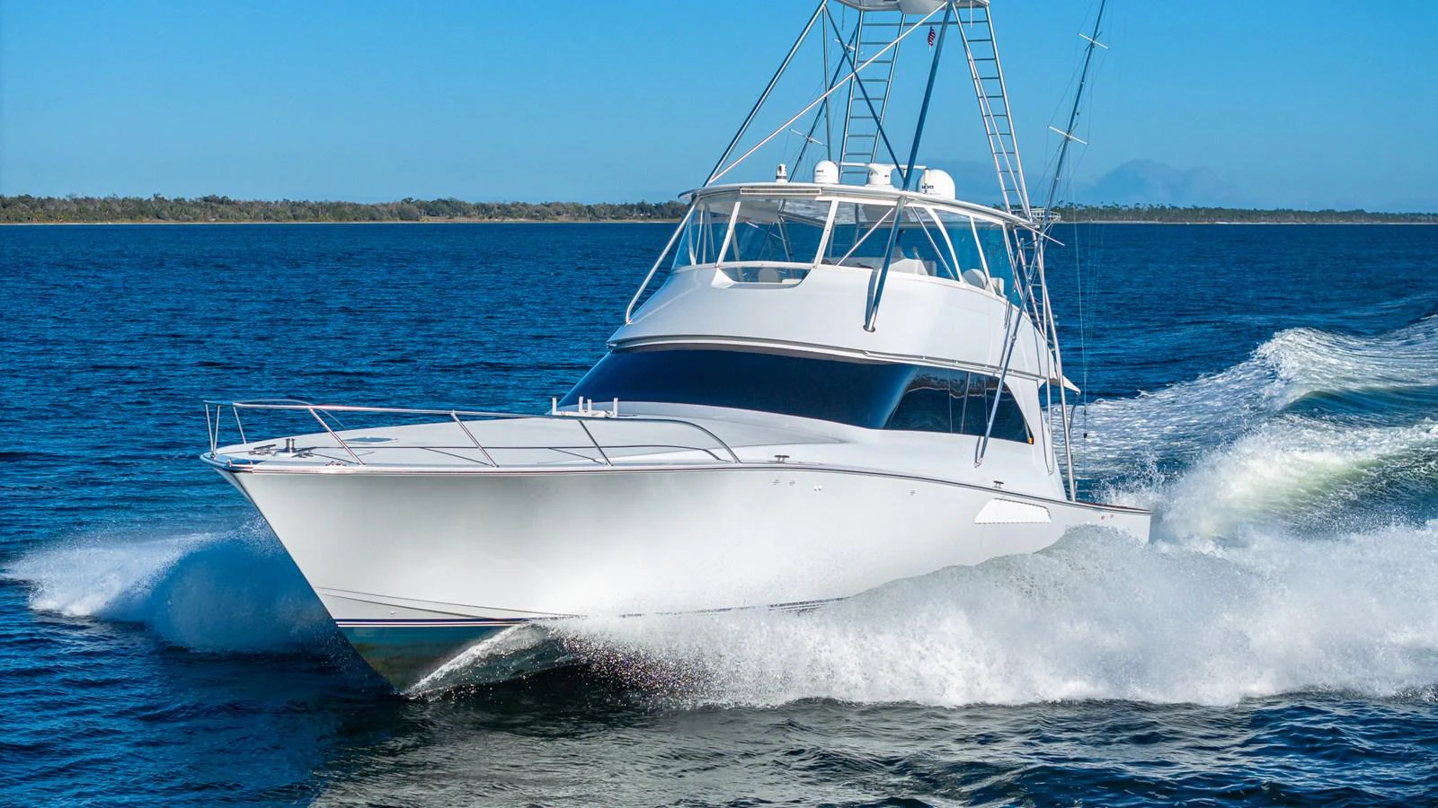 A sleek white yacht cruises swiftly through the water on a clear day. aboard FIRST BITE Yacht for Sale