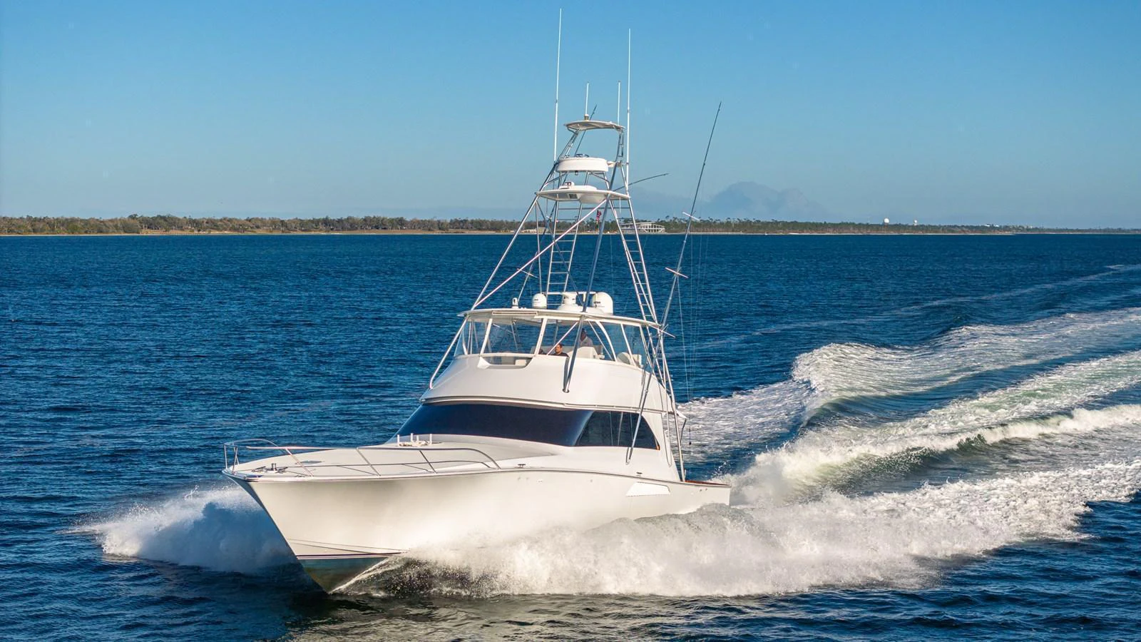 A sleek yacht cruises swiftly through the open water, leaving a trail of white foam behind. aboard FIRST BITE Yacht for Sale