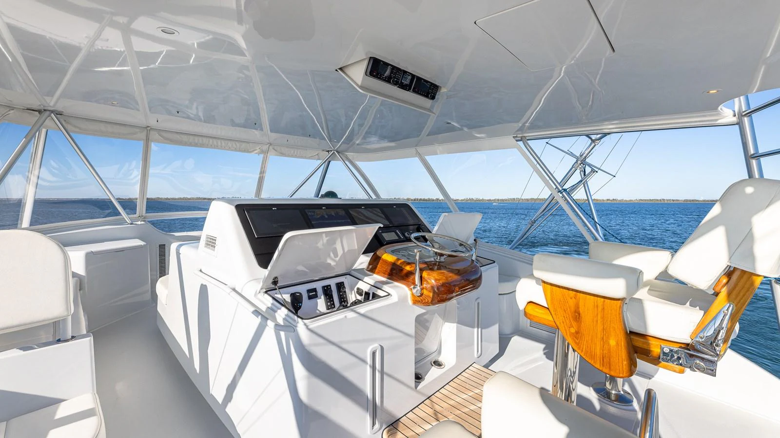 The helm area features modern navigation equipment and comfortable seating with a panoramic view of the sea. aboard FIRST BITE Yacht for Sale