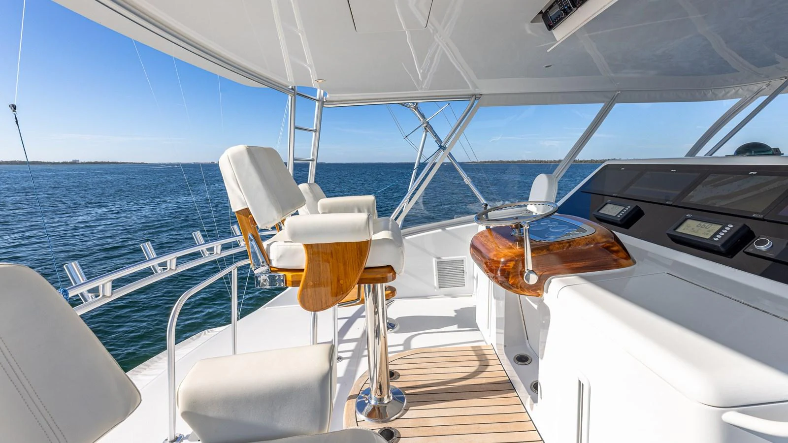 The helm area features luxurious seating and state-of-the-art navigation equipment, offering a commanding view of the open water. aboard FIRST BITE Yacht for Sale