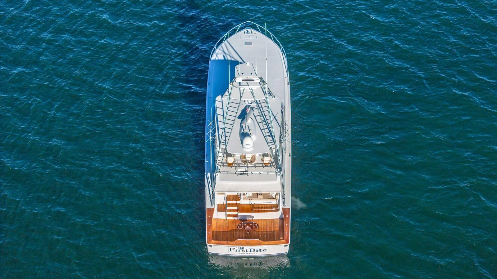 Aerial view of a yacht cruising on the open water, showcasing its sleek design and spacious deck. aboard FIRST BITE Yacht for Sale