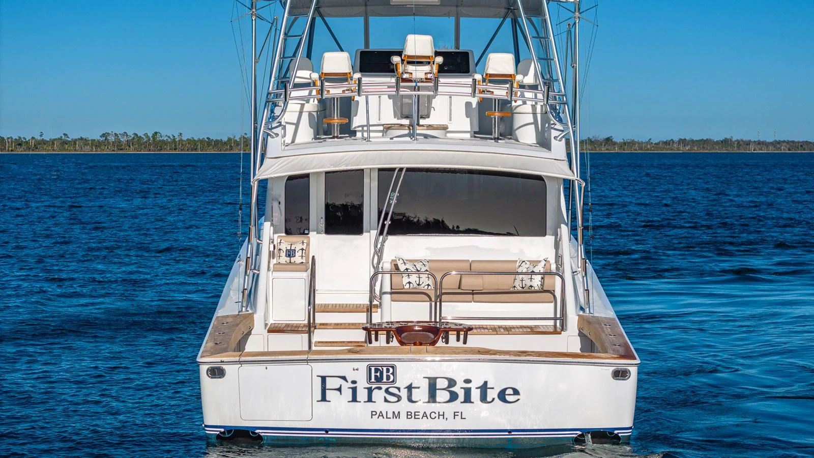 The yacht's stern showcases a spacious deck with comfortable seating and a clear view of the open water. aboard FIRST BITE Yacht for Sale