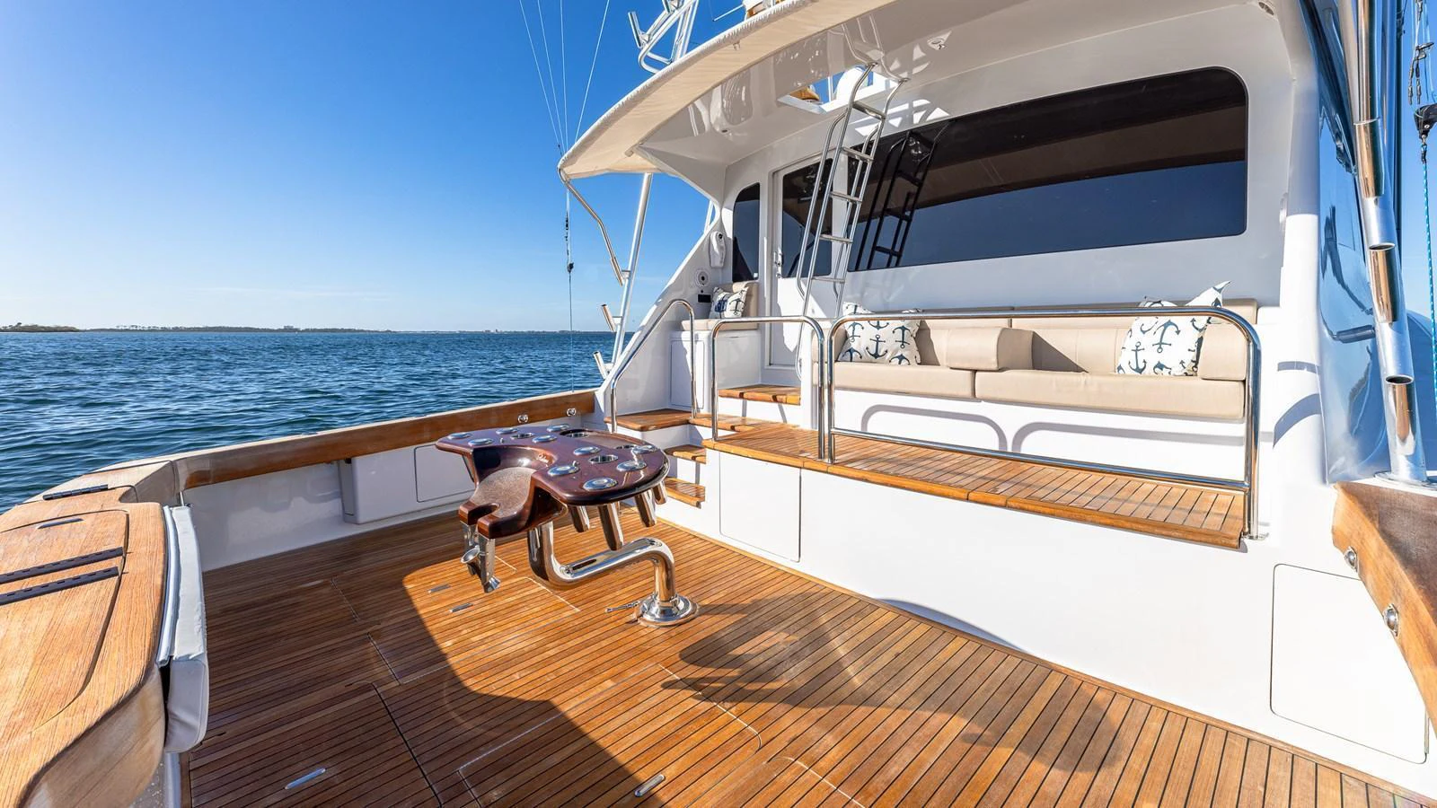 The aft deck features a spacious seating area with a polished wooden floor, perfect for relaxation and fishing. aboard FIRST BITE Yacht for Sale