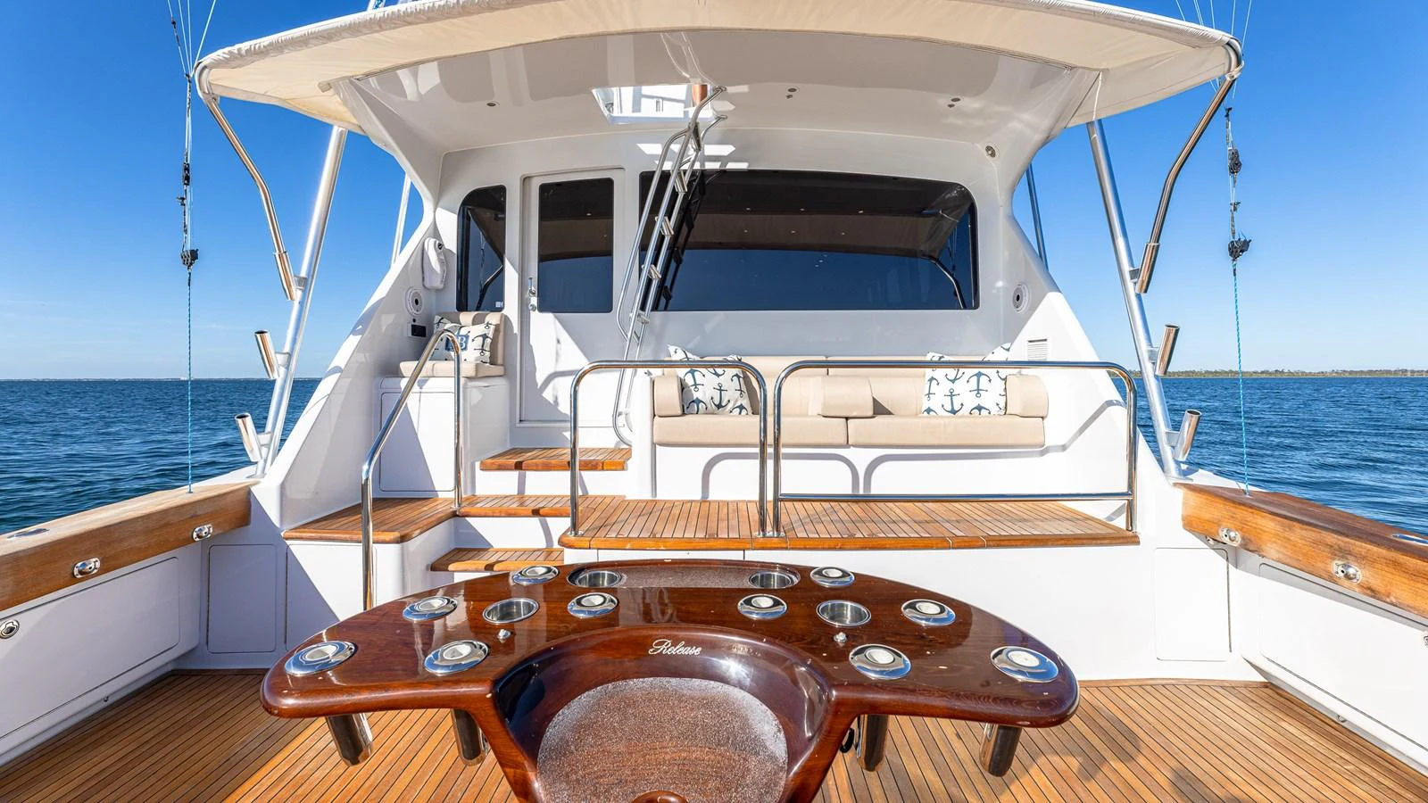The aft deck features a spacious seating area with a polished wooden table, perfect for outdoor relaxation and entertainment. aboard FIRST BITE Yacht for Sale