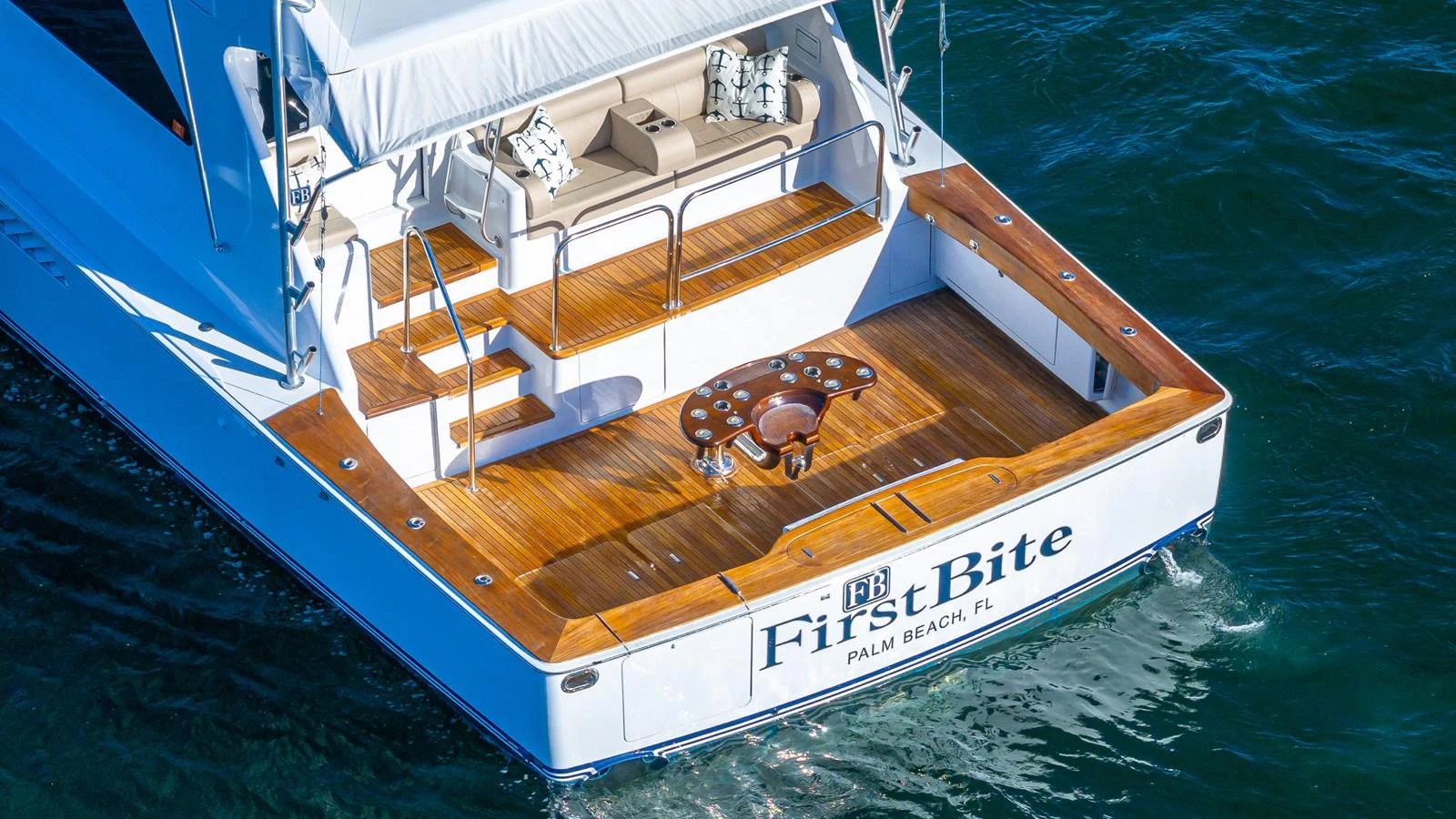 The yacht's aft deck features a spacious and inviting area with comfortable seating and a polished wooden finish. aboard FIRST BITE Yacht for Sale